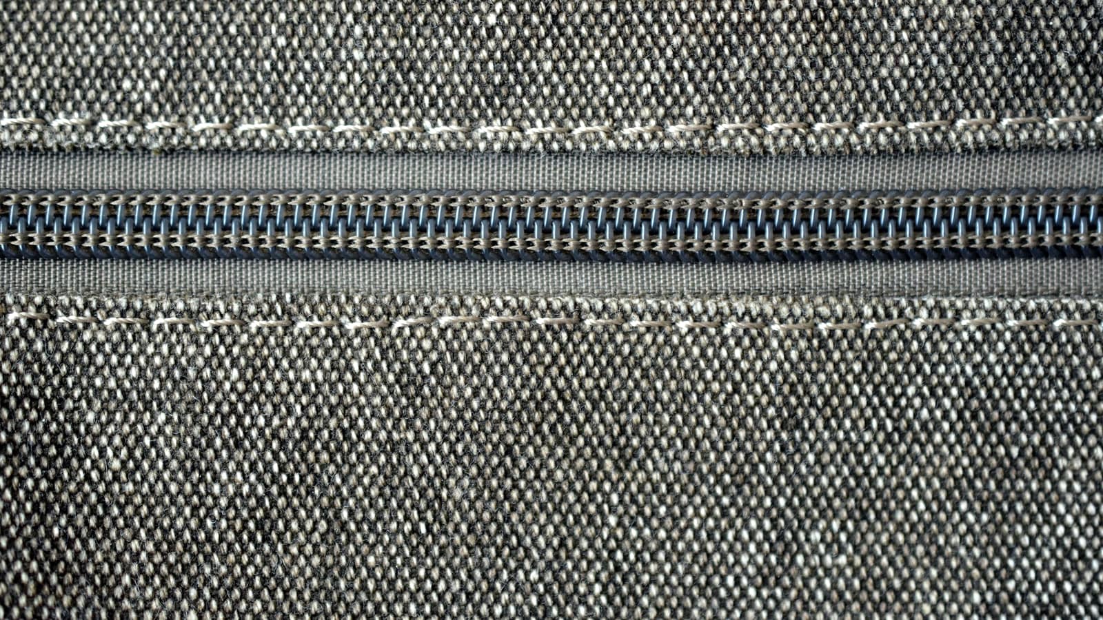 A coil zipper set into woven fabric. A trim like this carries its own lead time and its own minimum, decided long before the garment it closes.