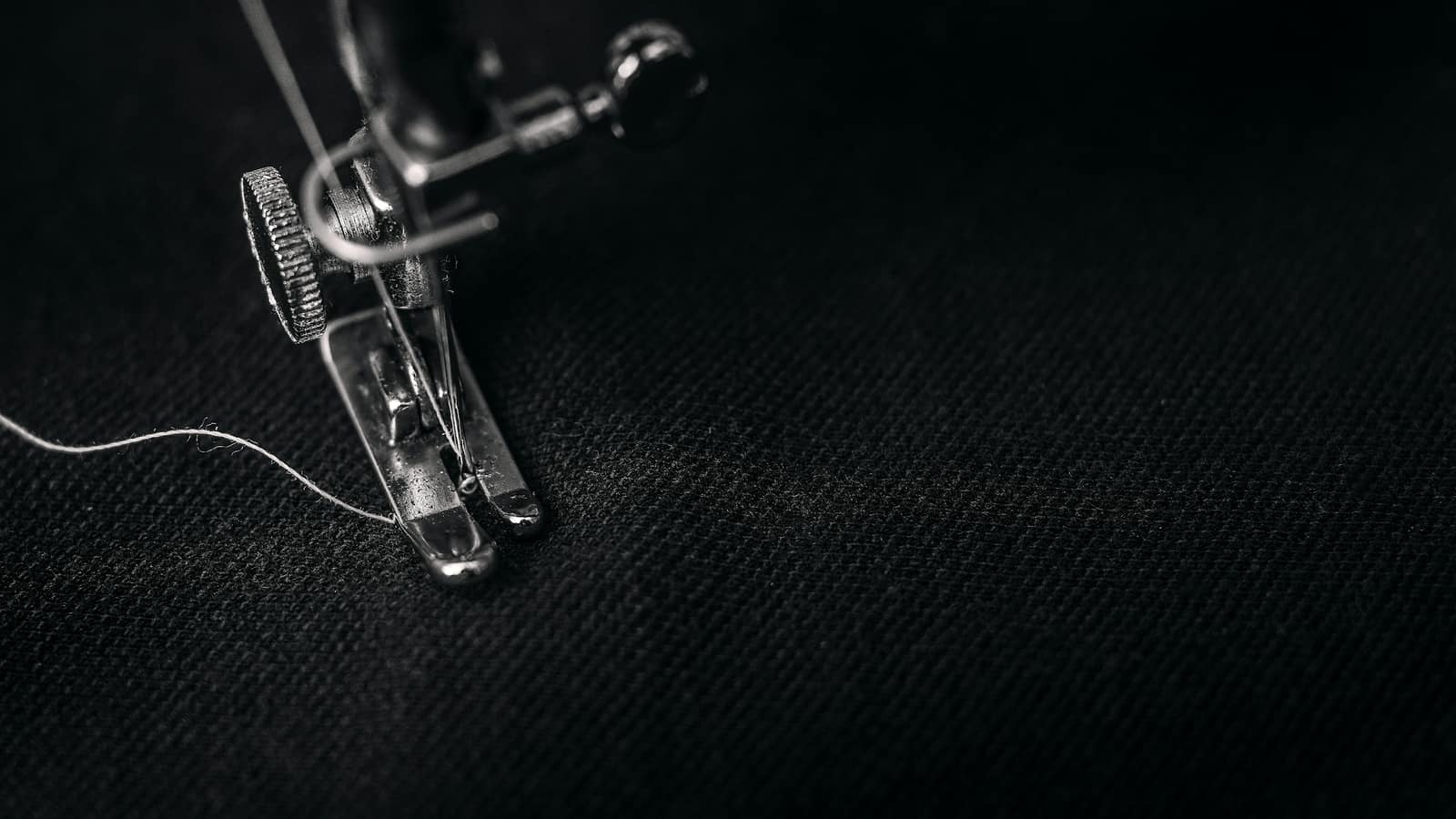 Calico pinned along a seam line over a drafted pattern. By this stage the commercial questions should already be settled.