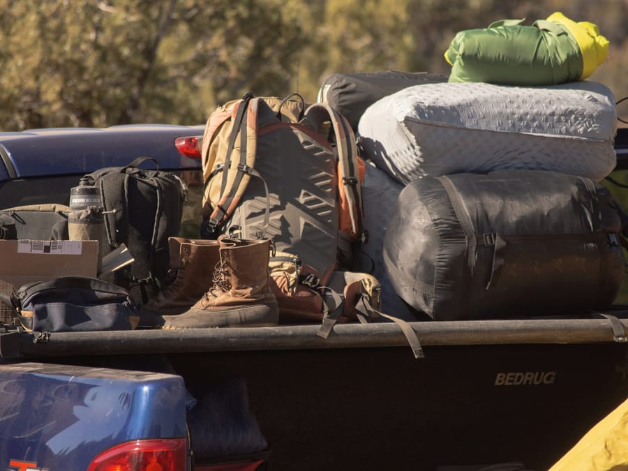 A pickup bed loaded with packs, duffels, and boots, Utah